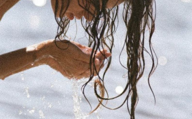 Femme se nettoyant le visage avec de l'eau pure plutôt qu'avec de l'eau micellaire