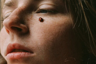 Zoom sur la pommette d'une femme avec une coccinelle dessus