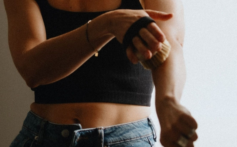 Zoom sur le bras d'une femme qui fait un brossage à sec