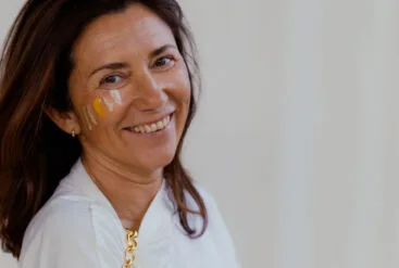 Zoom sur le visage rayonnant d'une femme avec les 4 crèmes Matière Brute Lab sur sa joue