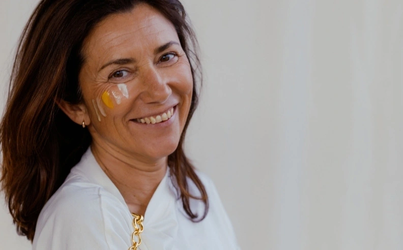 Zoom sur le visage rayonnant d'une femme avec les 4 crèmes Matière Brute Lab sur sa joue
