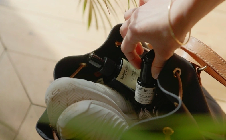 Zoom sur la main d'une femme qui prend le sérum bonne mine de son sac